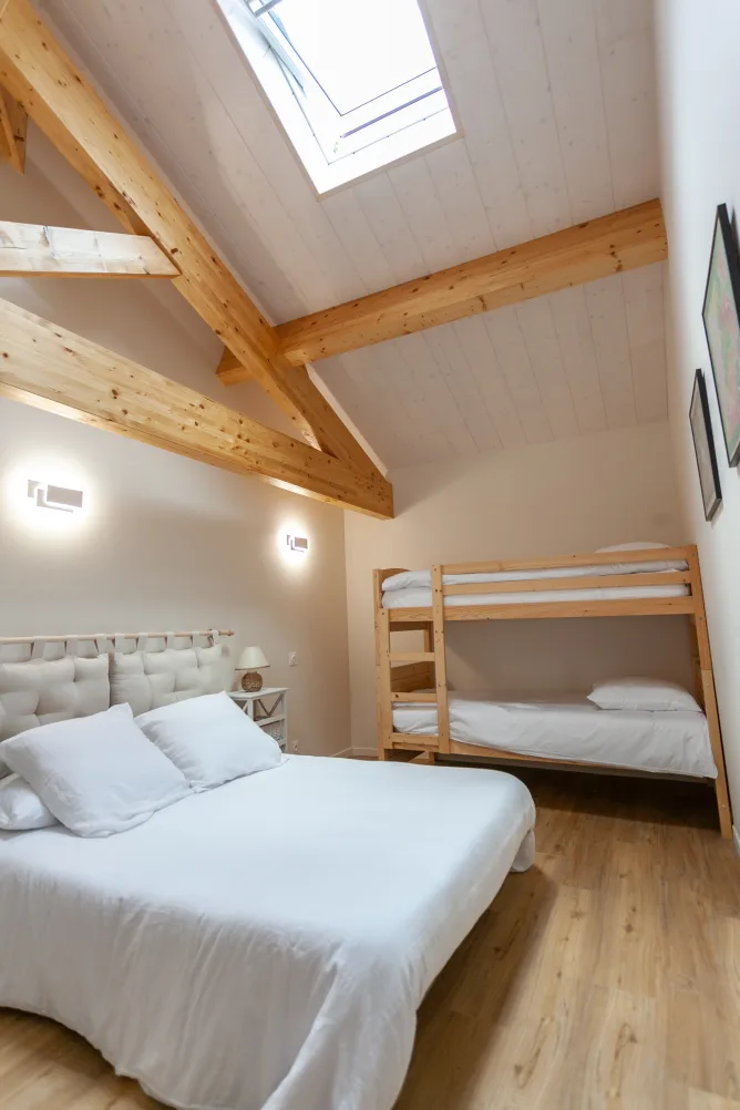 Bedroom with a double bed (140cm) and two bunk beds, featuring a remote-controlled Velux window